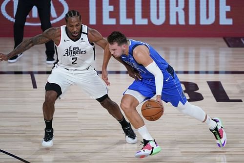 Luka Doncic #77 drives to the basket against Kawhi Leonard #2