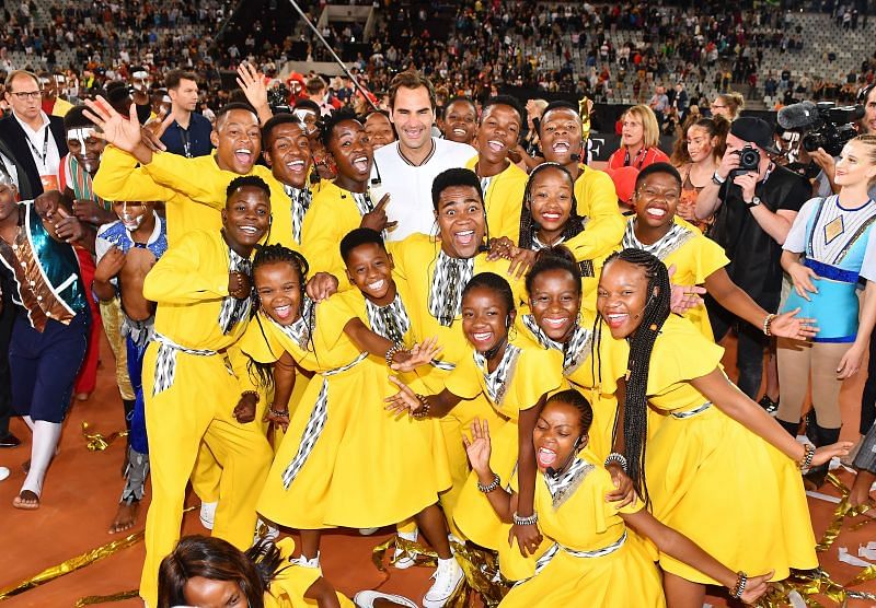 Roger Federer poses with kids at the Match In Africa 2020