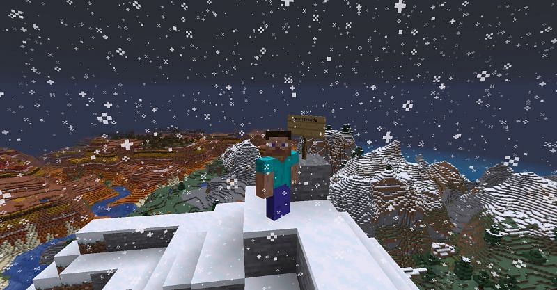 Steve standing on top of a mountain next to an oak sign in Minecraft (Image via Minecraft)
