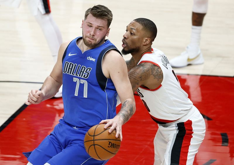 Luka Doncic #77 dribbles around Damian Lillard #0