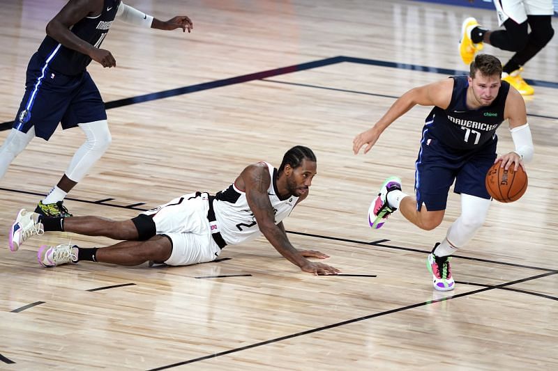 Kawhi Leonard #2 falls as Luka Doncic #77 dribbles past him. (Photo by Ashley Landis-Pool/Getty Images)