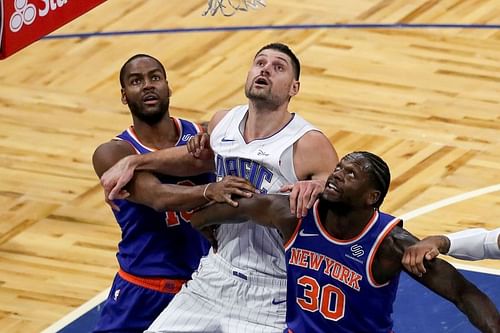 Alec Burks #18 and Julius Randle #30 of the New York Knicks fight for the rebound against Nikola Vucevic #9 of the Orlando Magic