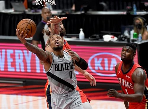 Damian Lillard (#0) lays the ball up past Zion Williamson (#1).