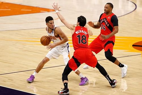 Devin Booker of the Phoenix Suns in NBA action against Yuta Watanabe of the Toronto Raptors