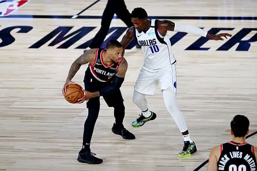 Damian Lillard #0 of the Portland Trail Blazers controls the ball against Dorian Finney-Smith #10 of the Dallas Mavericks