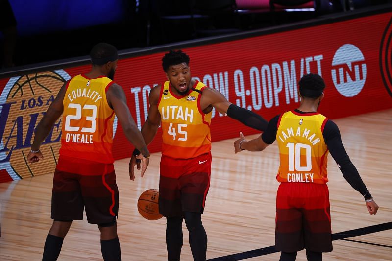 Donovan Mitchell (#45) of the Utah Jazz celebrates with teammates Royce O'Neale and Mike Conley.