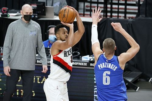 CJ McCollum of the Portland Trail Blazers shoots over Kristaps Porzingis of the Dallas Mavericks