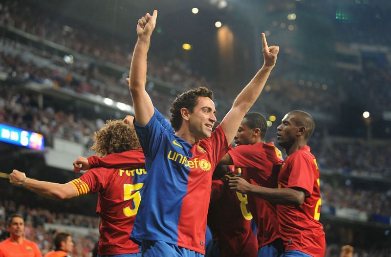 Xavi celebrates with teammates after providing four assists in El Clasico