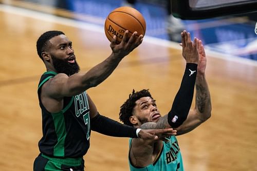 Jaylen Brown (#7) of the Boston Celtics looks to shoot over Miles Bridges (#0) of the Charlotte Hornets.