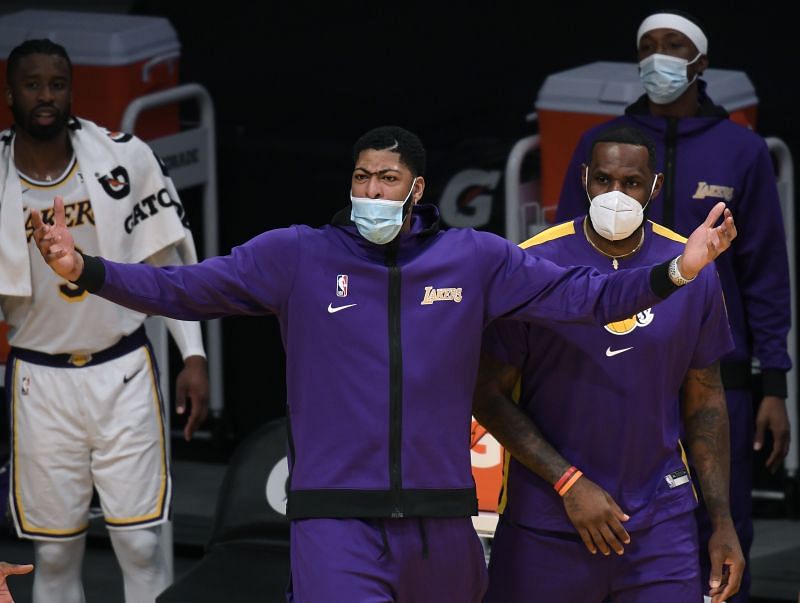 Anthony Davis #3 and LeBron James #23 react as they watch a preseason game.