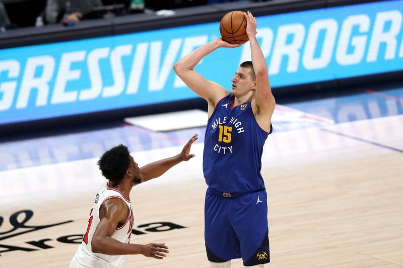 Nikola Jokic #15 puts up a three-point shot against Thaddeus Young #21.