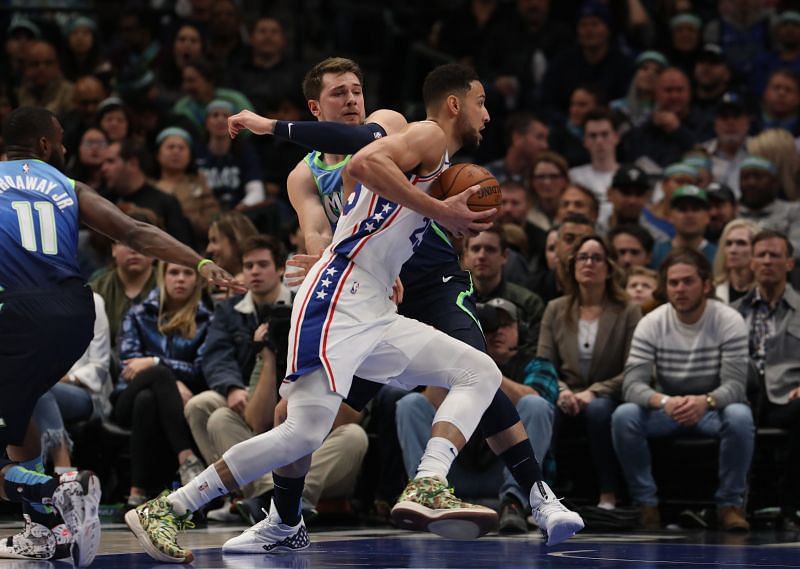 Ben Simmons (#25) dribbles the ball against Luka Doncic (#77).