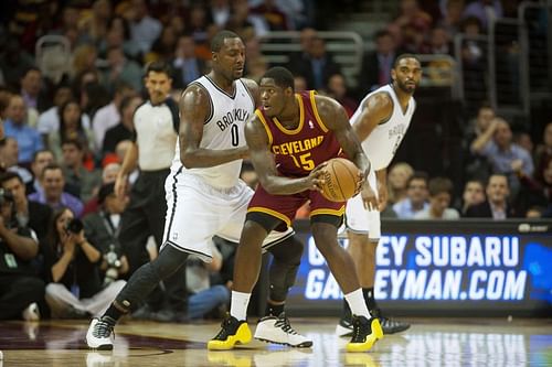 Anthony Bennett #15 looks for a pass against the Brooklyn Nets. Michael Olowokandi #34 dribbles the ball in a game versus the Bucks.