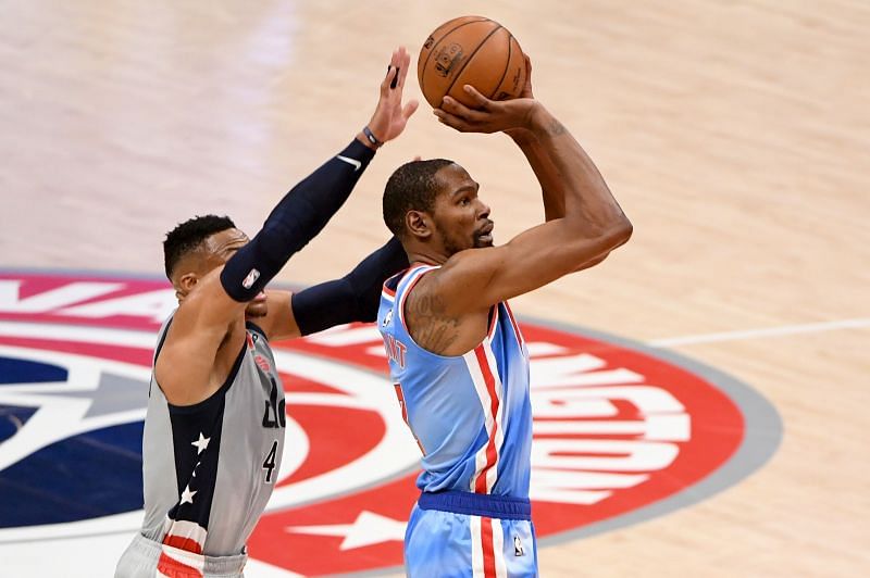 Kevin Durant taking a shot while Russell Westbrook tries to block him