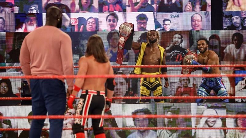 AJ Styles and Omos look on at the victorious New Day