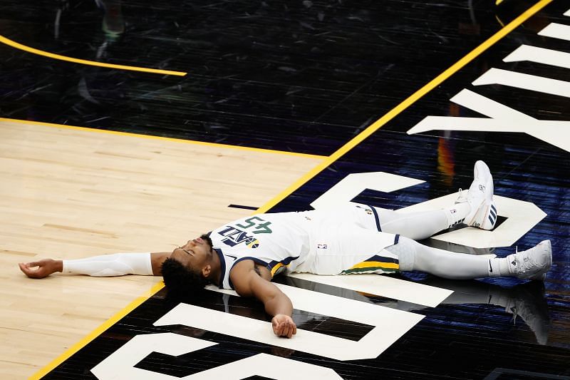 Donovan Mitchell #45 lays on the court after scoring and drawing a foul.