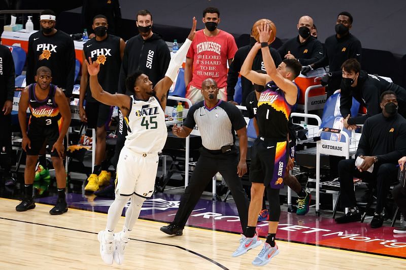 Devin Booker of the Phoenix Suns shoots over Utah Jazz&#039;s Donovan Mitchell