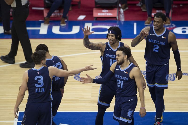 Grayson Allen #3, Brandon Clarke #15, Tyus Jones #21 and Xavier Tillman #2 celebrate on the court 