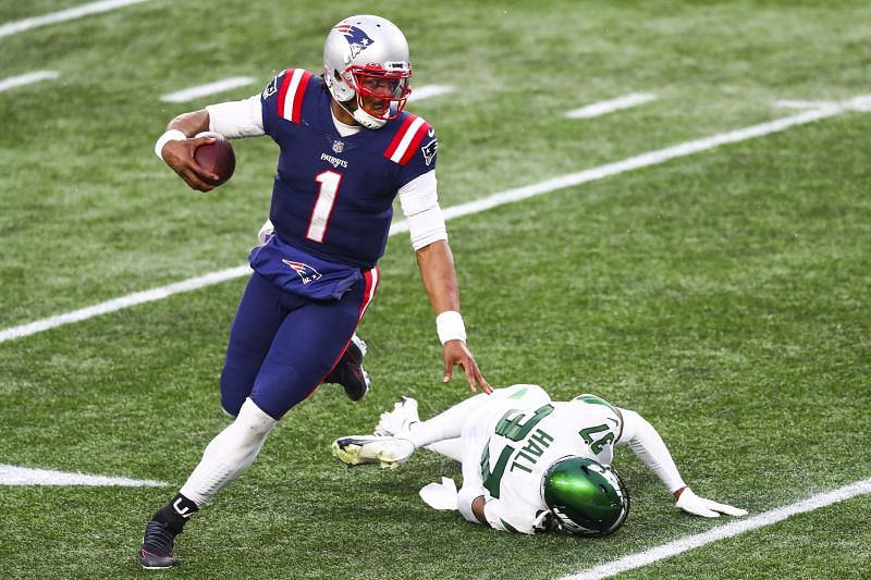 New England Patriots quarterback Cam Newton evades a tackler against the New York Jets on Jan. 3, 2021.