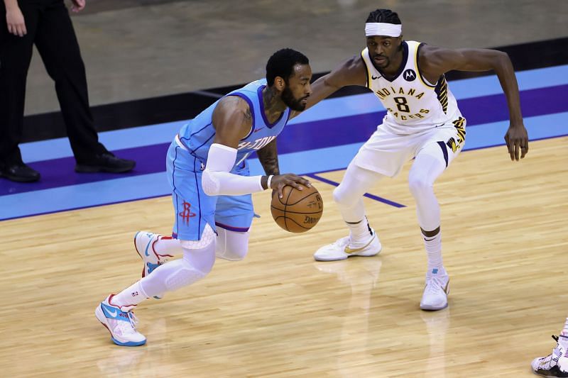 John Wall #1 drives past Justin Holiday #8.