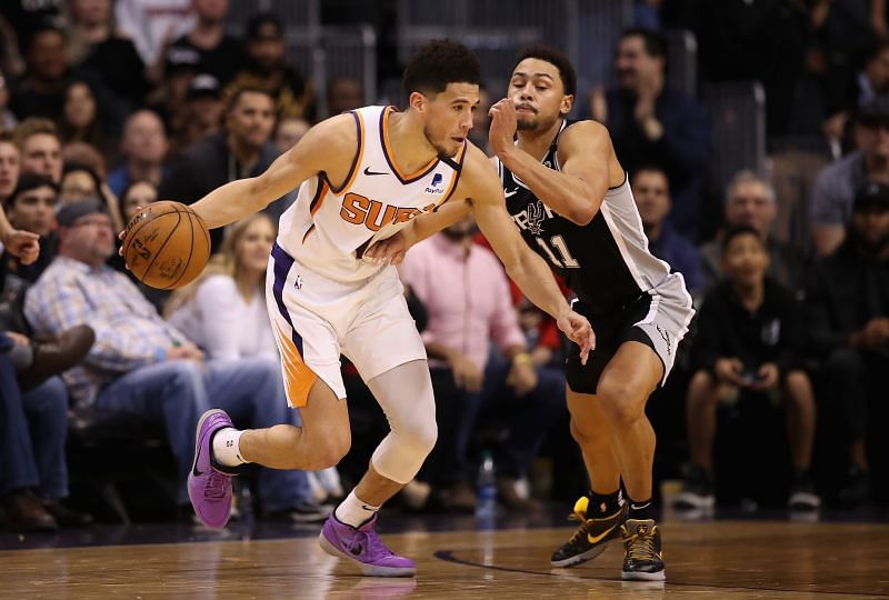 Devin Booker #1 of the Phoenix Suns handles the ball against Bryn Forbes #11 of the San Antonio Spurs