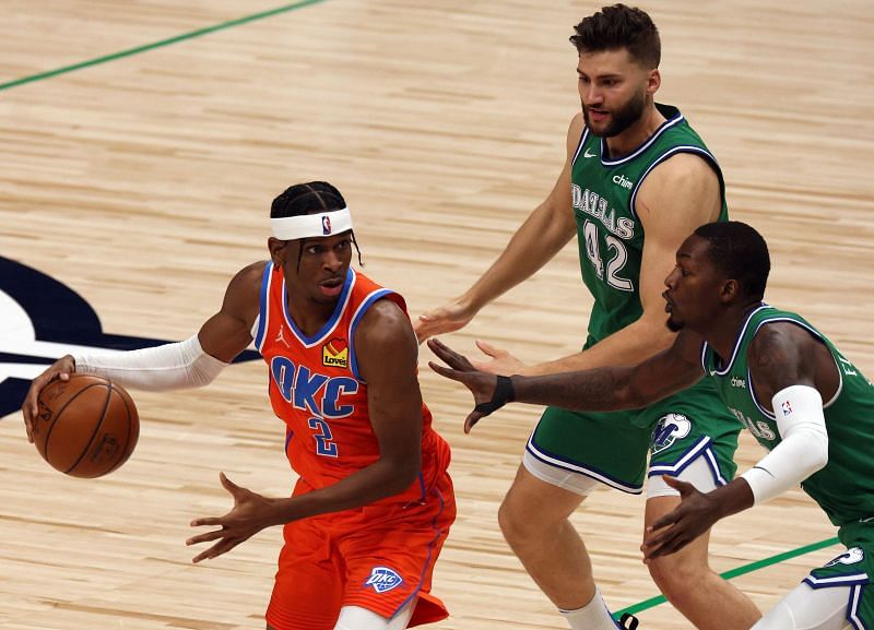 Shai Gilgeous-Alexander (#2) goes against two Dallas Mavericks players.