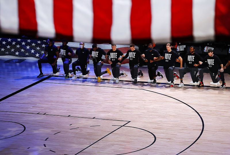 The Miami Heat kneel during the national anthem