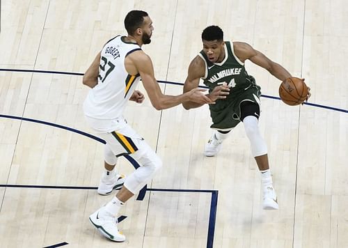 Giannis Antetokounmpo #34 of the Milwaukee Bucks drives into Rudy Gobert #27 of the Utah Jazz.