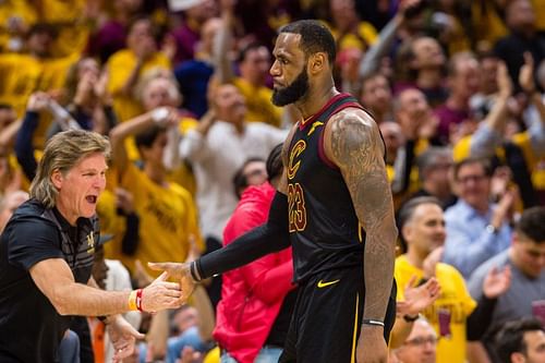 LeBron James #23 of the Cleveland Cavaliers celebrates with a fan after scoring against the Toronto Raptors.