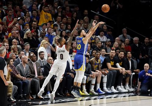 Stephen Curry #30 of the Golden State Warriors shoots the ball against Damian Lillard #0 of the Portland Trail Blazers