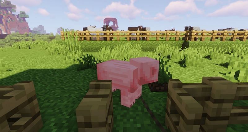 Shown: A player using a Lead to get a Pig into its enclosure (Image via Minecraft)