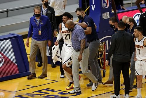 Jamal Murray #27 of the Denver Nuggets is helped off the court after an injury in their game against the Golden State Warriors.