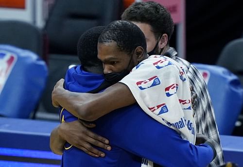 Kevin Durant and Draymond Green embrace each other during a Brooklyn Nets-Golden State Warriors game.