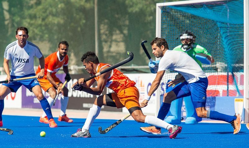 India&#039;s Shilanand Lakra (in yellow) takes a shot on goal against Argentina. (Source: HI)