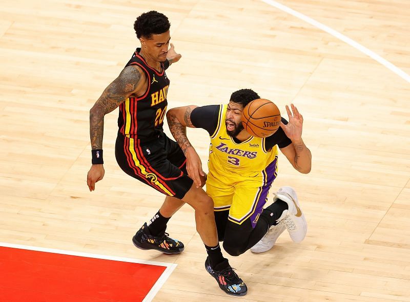 Anthony Davis #3 draws a foul as he falls the court against John Collins #20.