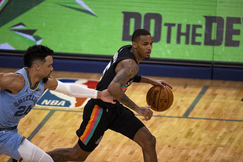 Dejounte Murray (#5) dribbles the ball up the court as Dillon Brooks (#24) reaches to defend.