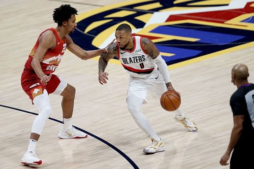 Damian Lillard #0 of the Portland Trailblazers drives against Zeke Nnaji #22 of the Denver Nuggets.