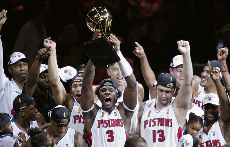 Ben Wallace #3 (center) of the Detroit Pistons holds up the Larry O&#039;Brien NBA trophy in 2004.