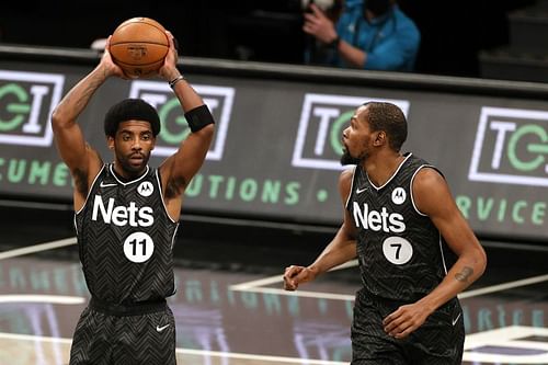 Kyrie Irving #11 looks to pass as Kevin Durant #7 looks on.