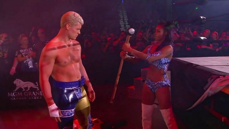 Brandi Rhodes offering a symbolic sledgehammer to Cody.