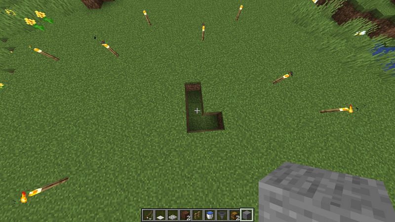 Players should dig a small L-shaped hole in the ground (Image via Minecraft)