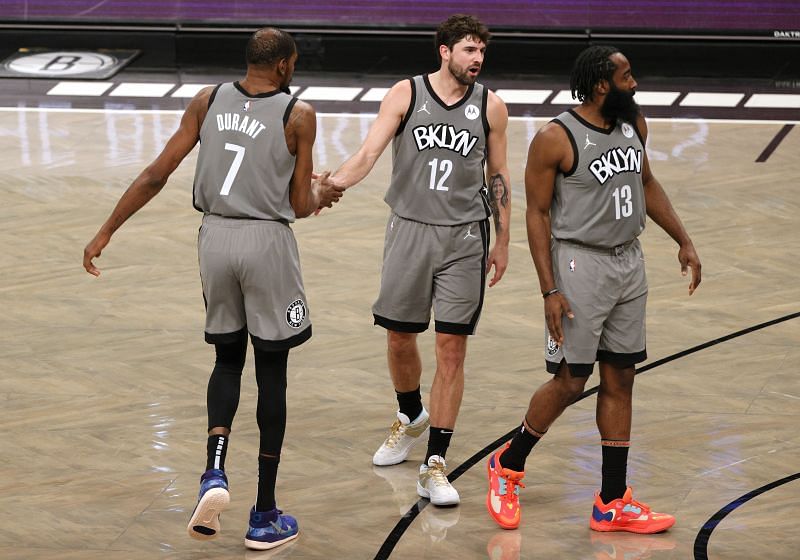 Brooklyn Nets' #12 Joe Harris shares a moment with #7 Kevin Durant and #13 James Harden