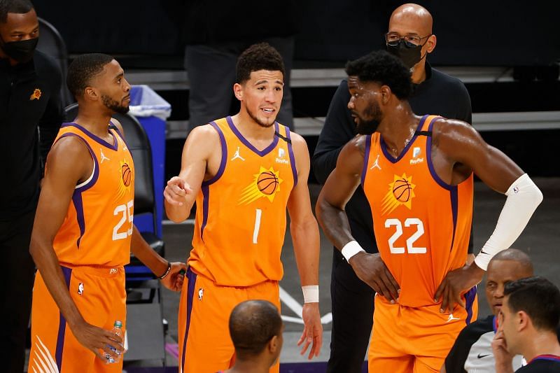 Devin Booker #1 of the Phoenix Suns talks with Mikal Bridges #25 and Deandre Ayton #22 during the first half of a game