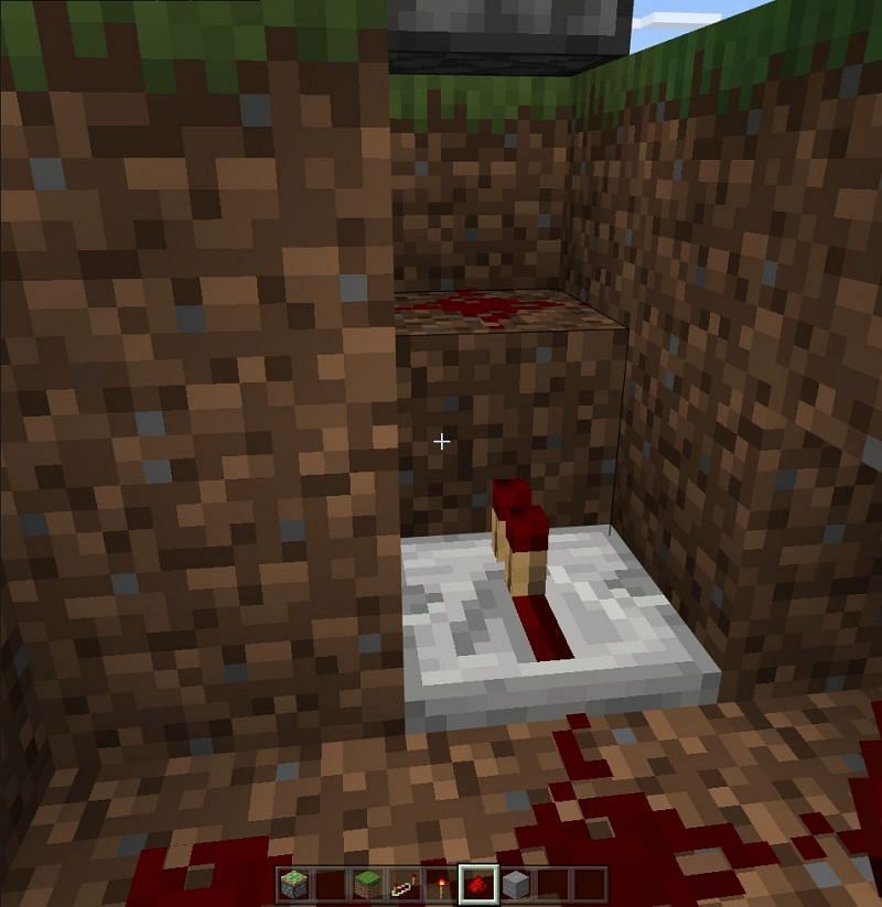 placing redstone toches underneath pistons to make secret door.png