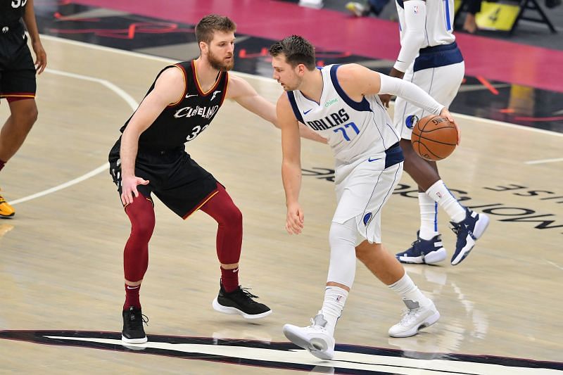 Luka Doncic #77 drives to the basket around Dean Wade #32