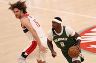 Bobby Portis #9 of the Milwaukee Bucks dribbles past Robin Lopez of the Washington Wizards