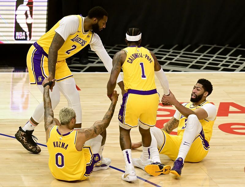 Anthony Davis #3 and Kyle Kuzma #0 react as they are helped up off the floor by Kentavious Caldwell-Pope #1 and Andre Drummond #2