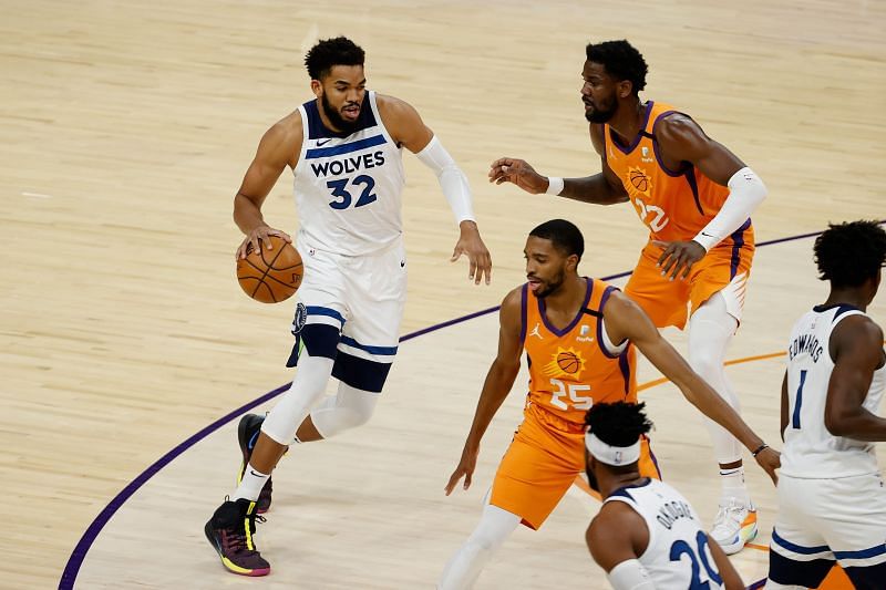 Karl-Anthony Towns (#32) controls the ball against Deandre Ayton (#22).