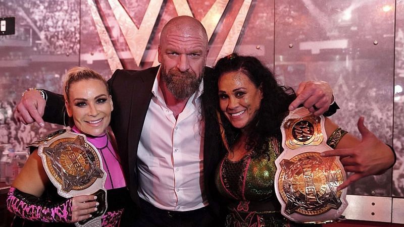 Tamina and Natalya with Triple H after their title victory