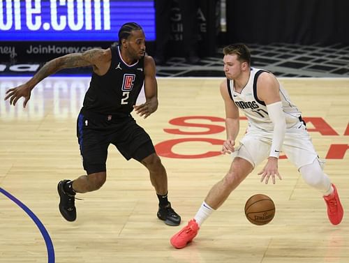 Luka Doncic #77 dribbles away from Kawhi Leonard #2